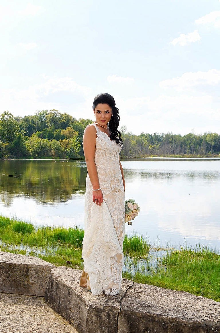 bride in front of pond at royal ambassador
