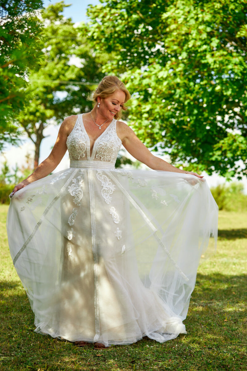 Bride at Country Wedding Admires her Beautiful Dress