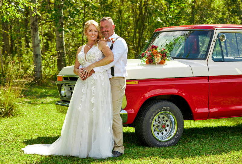 Bride and Groom Pose by Classic Pickup Truck at Rustic Country Wedding