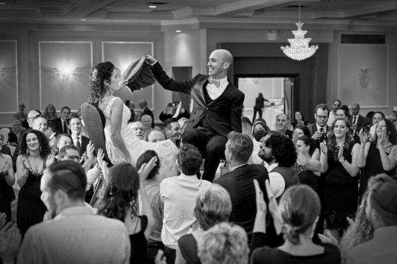 The bride and groom hold a handkerchief between them to symbolize their union, during the Hora Dance at a Jewish Wedding