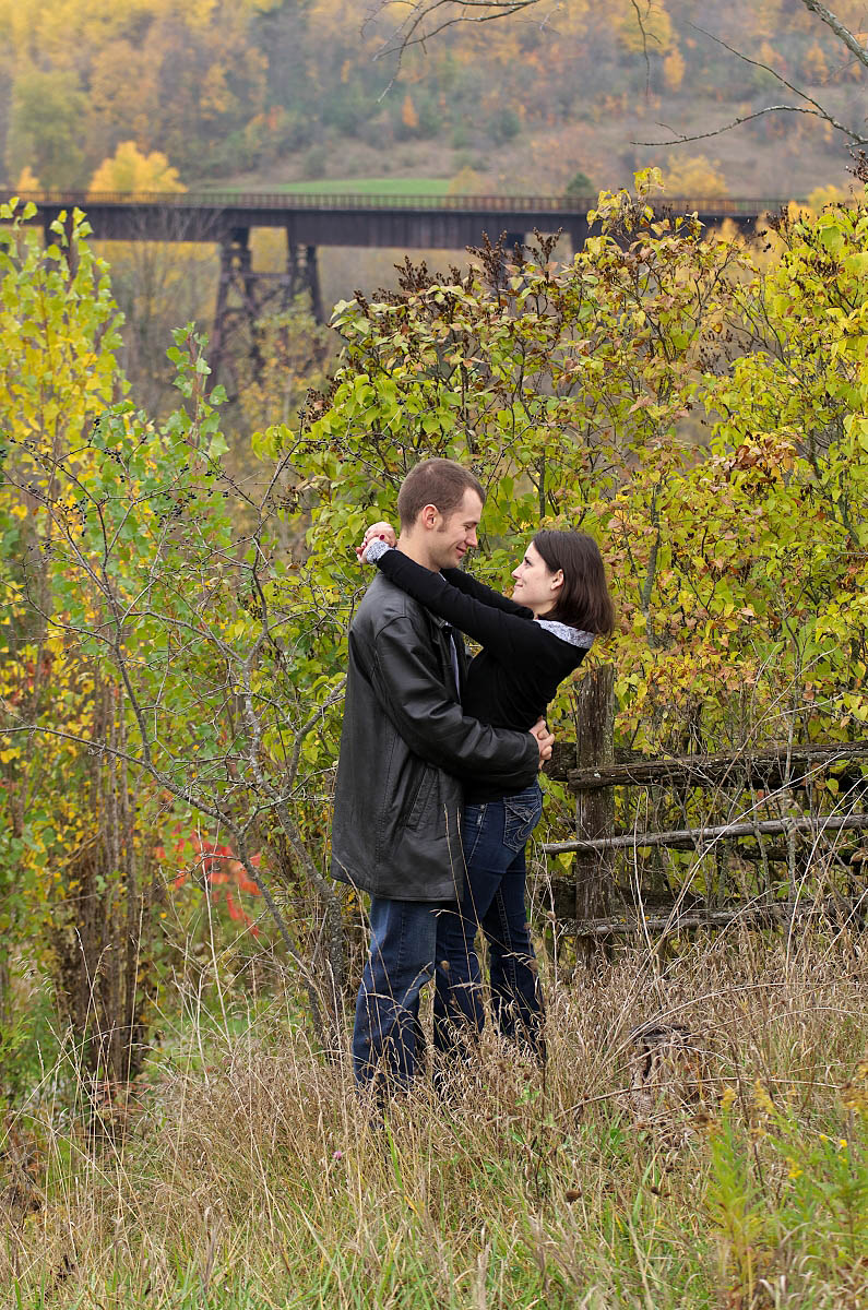 Young couple kisses near Orange Corners Bridge in Kawartha Lakes engagement photography session