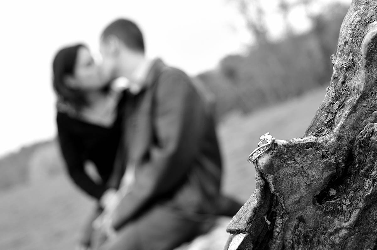 engagement ring in focus, couple our of focus