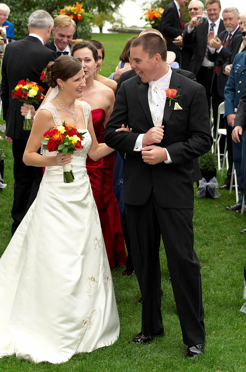 Dynamic groom and bride walk together down ceremony aisle as husband and wife at Eganridge wedding