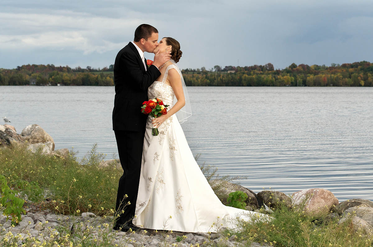 Bride and groom with wildflowers and lake at Eganridge wedding