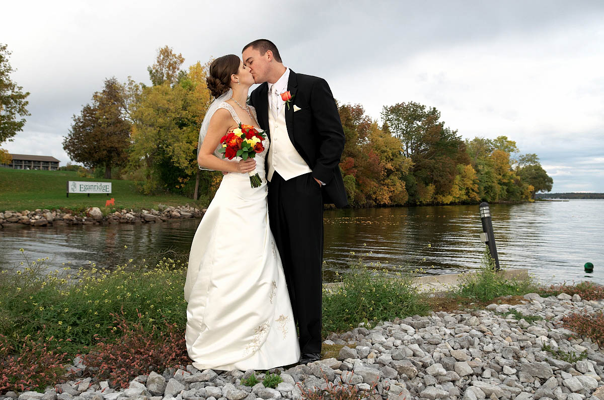 Bride and groom with wildflowers and lake at Eganridge wedding