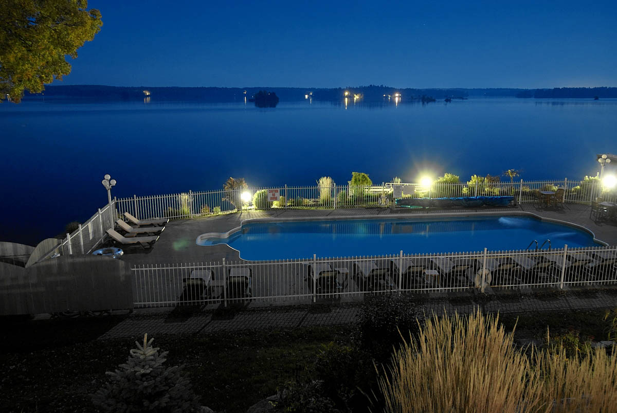 viamede's outdoor pool lit up a night on stoney lake
