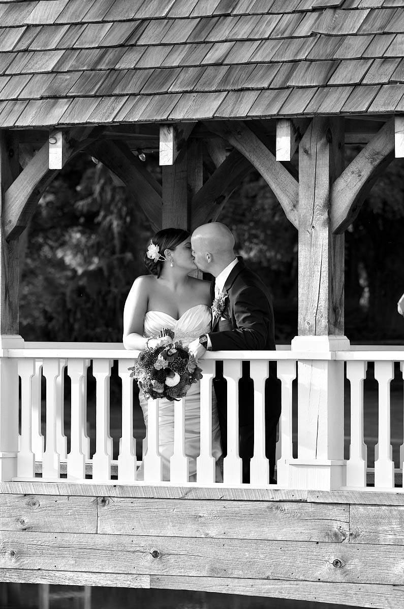 covered bridge wedding kiss in black and white