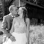 Black-and-white image of Wedding couple kissing in front of barn in Haliburton, Ontario