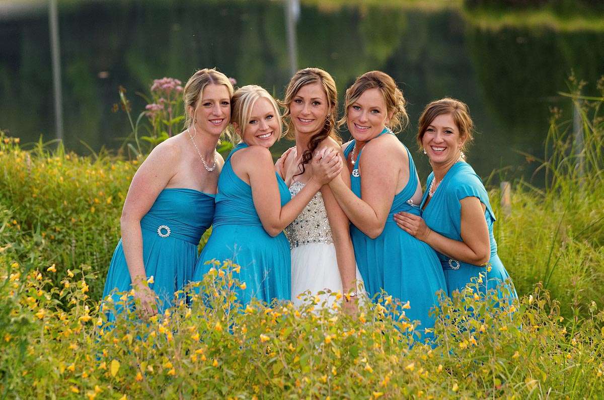 Bride and Bridesmaids Squeeze Together by the pond at Haliburton's Pinestone Resort