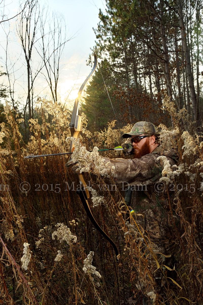 hunter with drawn arrow in recurve bow