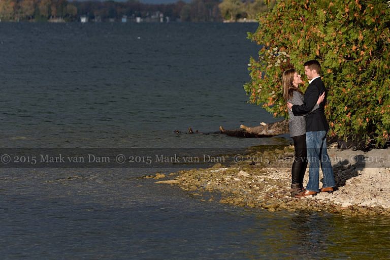 Couple kissing on shores of Lake Couchiching at Orillia engagement session at Leacock Museum