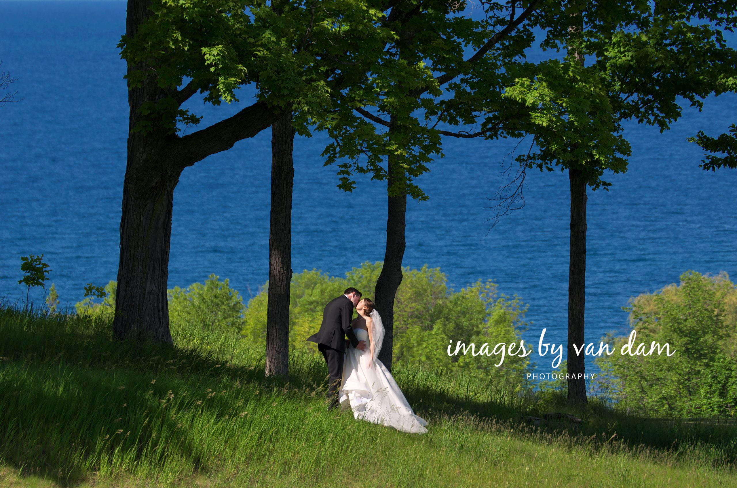 Bride and Groom Kiss Atop Ridge at Georgian Bay Golf Club