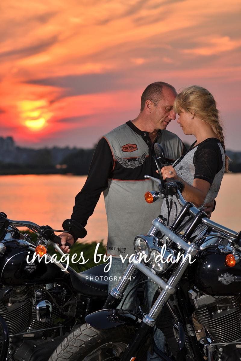 With their Harley Davidson motorcycles parked in front of Georgian Bay, a couple nestles into each other