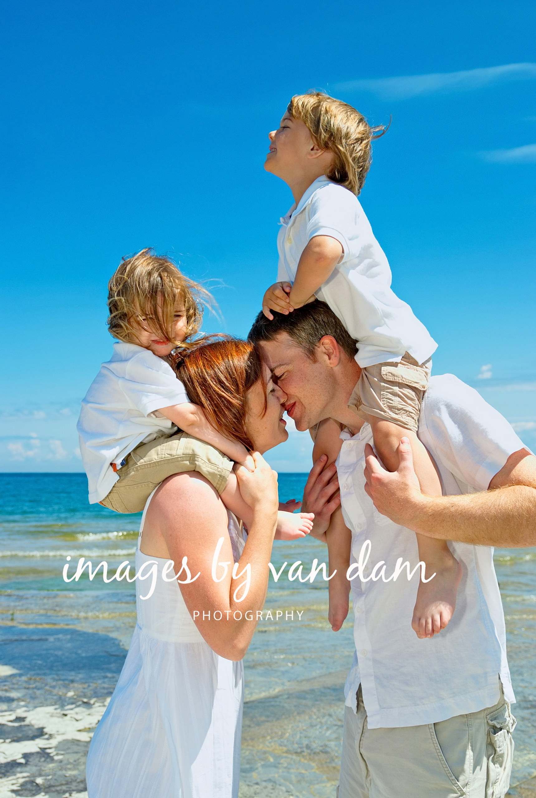With Children Perched on Shoulders, a Young Couple Sneaks a Kiss
