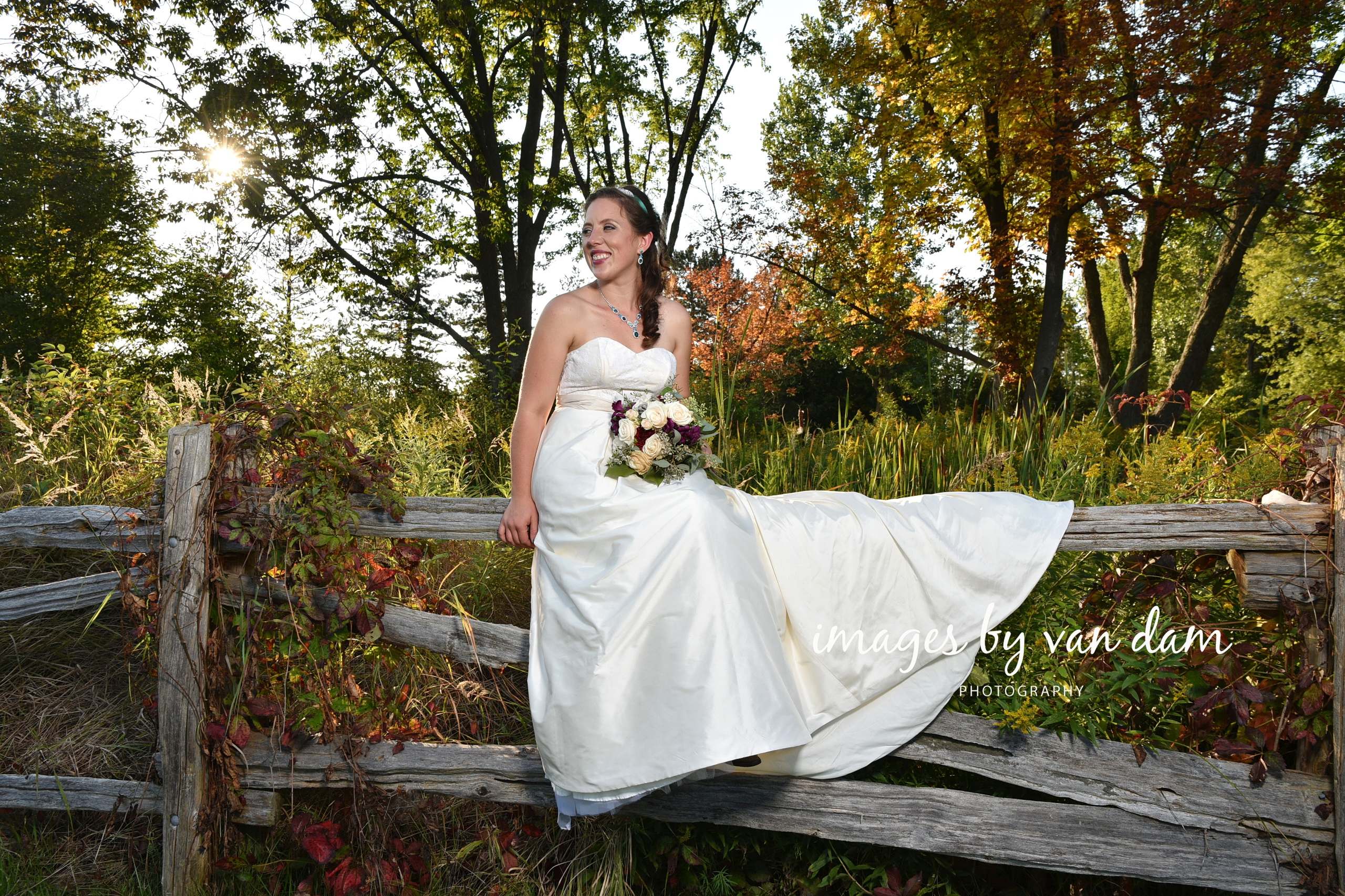 Beautiful Bride Sits on Split Rail Fence
