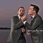 Two Grooms Blow Bubbles on Dock at Dusk