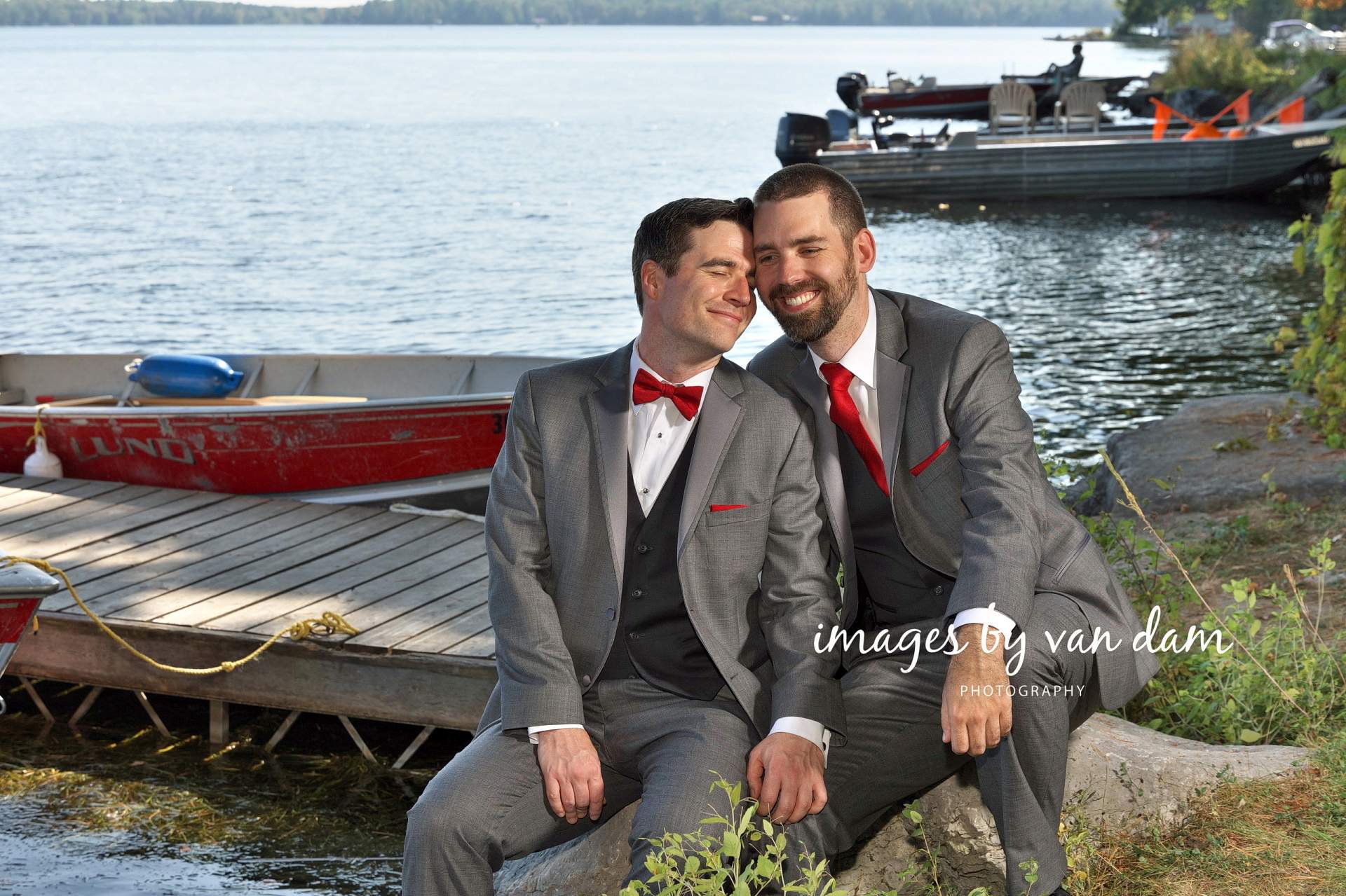 Two grooms snuggle on the dock after their Beachwood Resort wedding