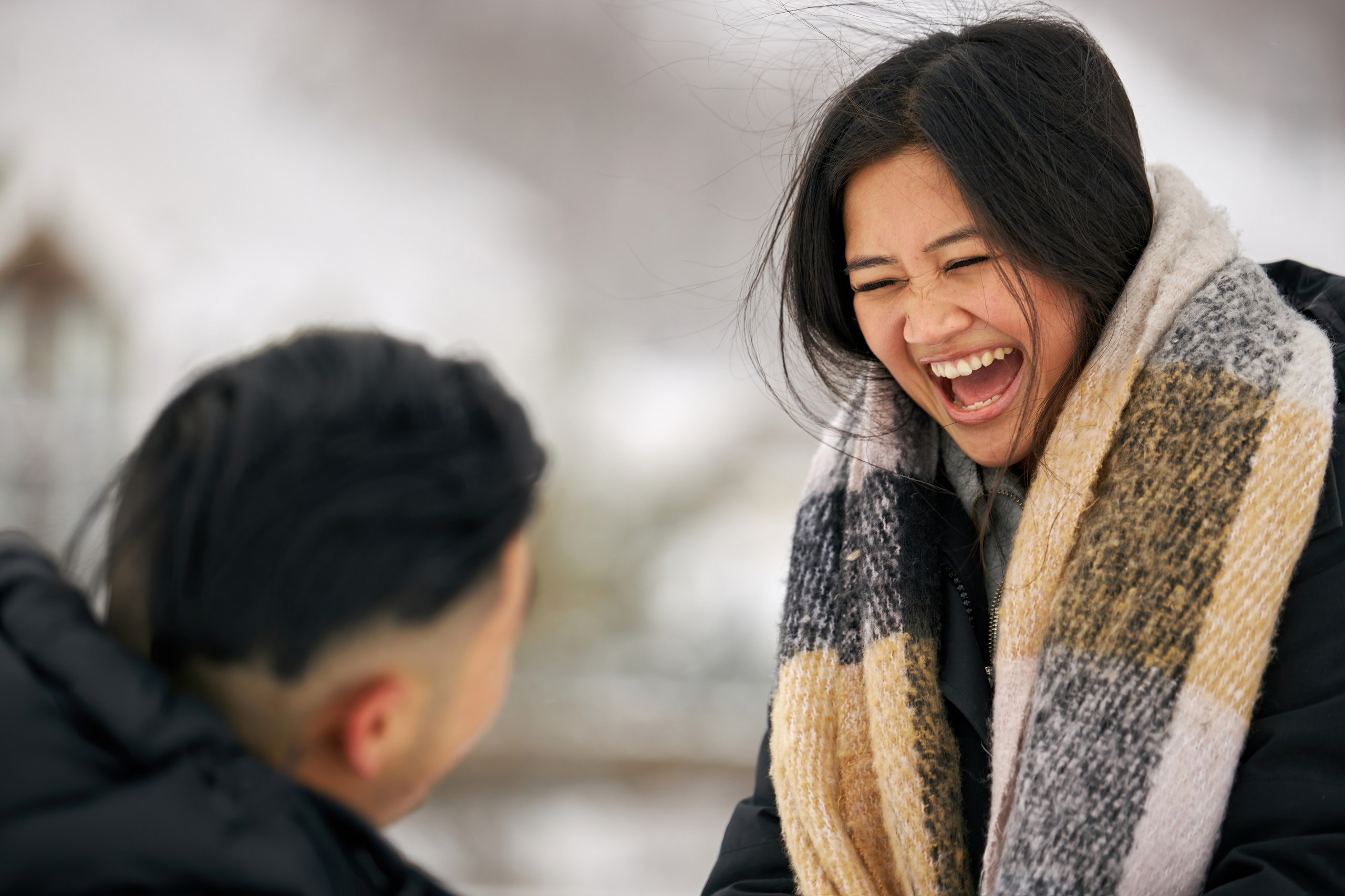 A young woman ecstatically reacts to her fiancé asking her to marry him