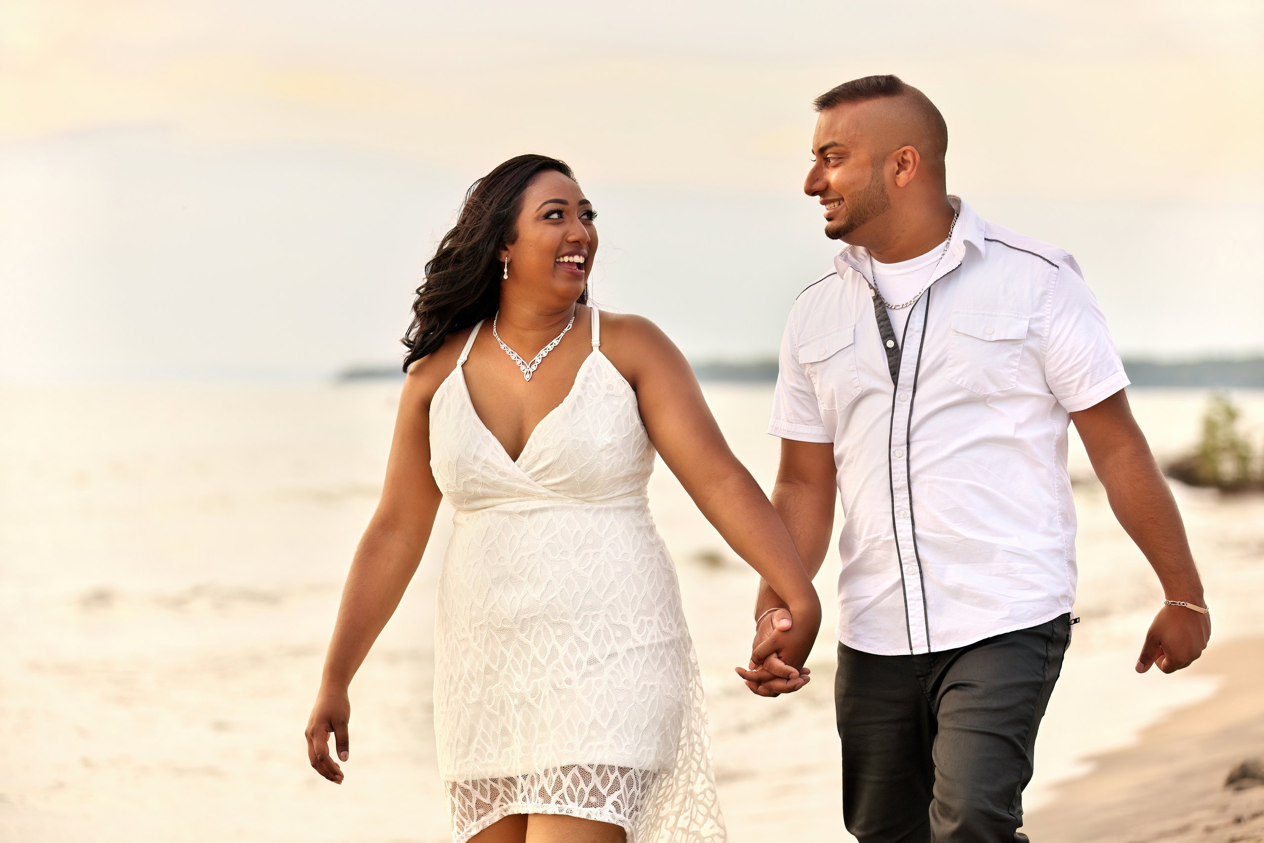 Stylish couple strolling down beach in Tiny Township