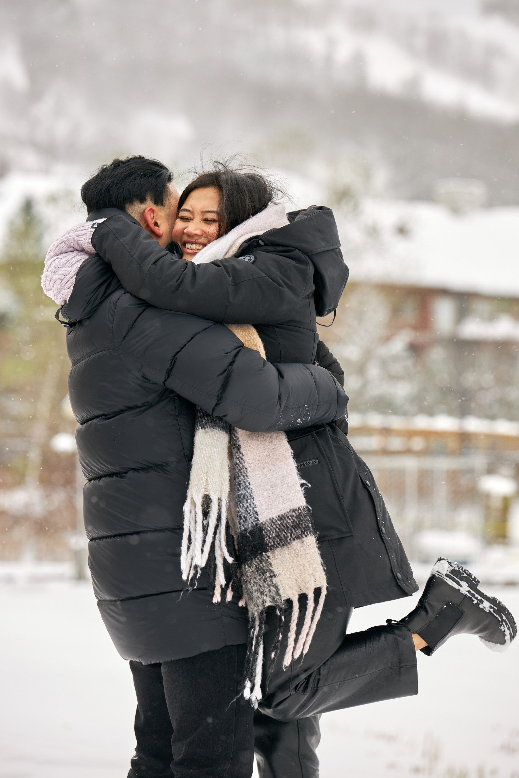 A young woman jumps into her fiancé's arms right after he asks her to marry him