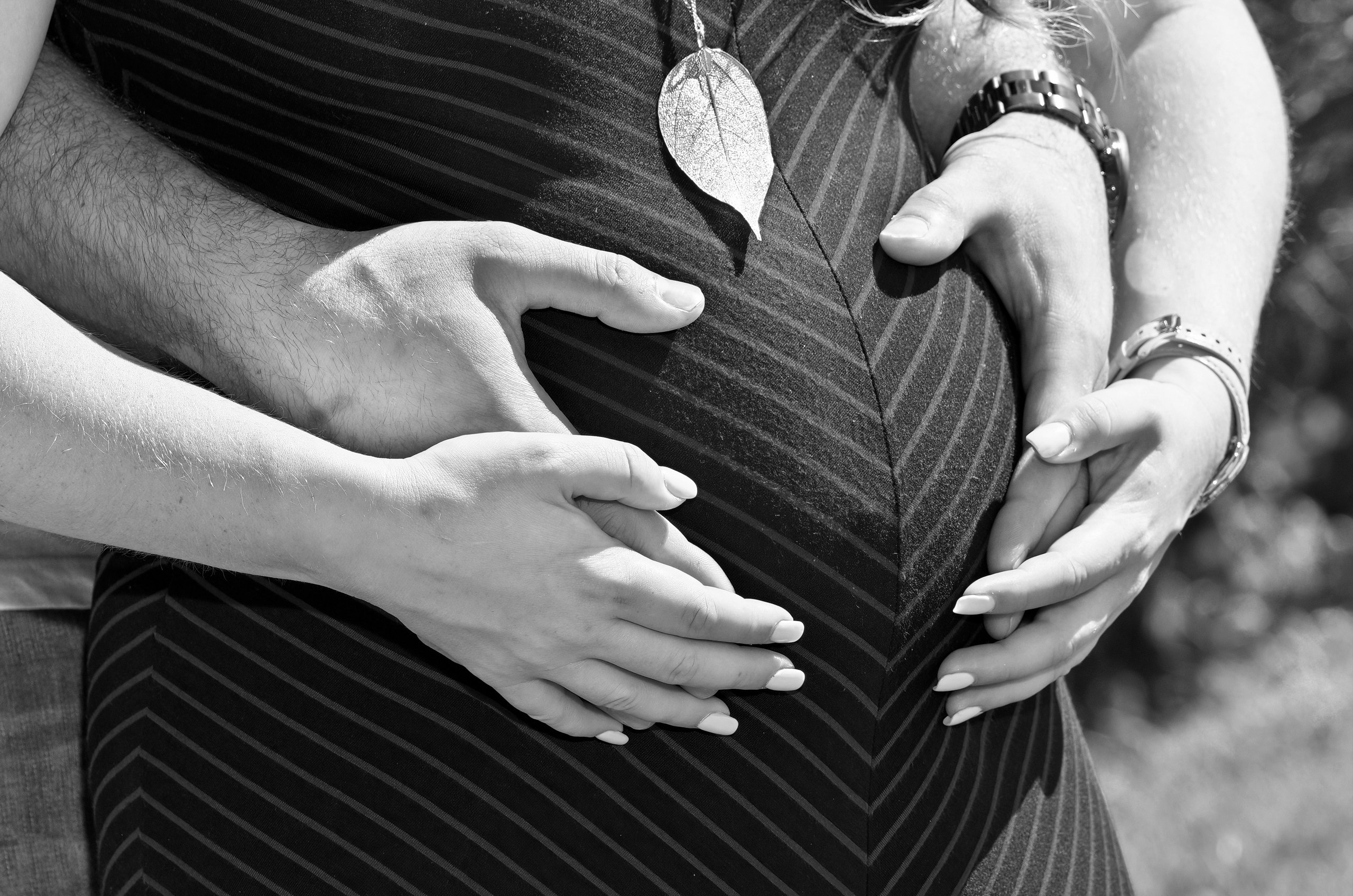 Maternity photo with father and mother's hands on mother's belly